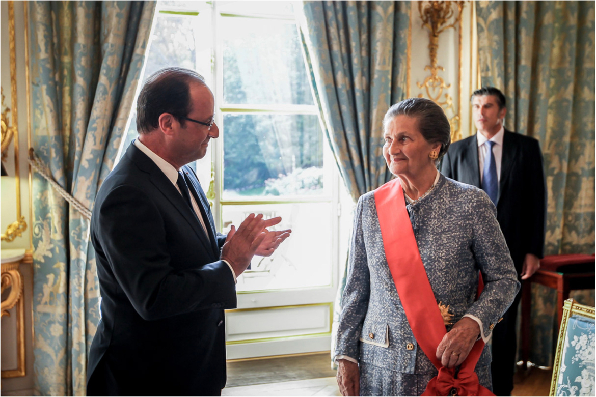 Photographie de la cérémonie de remise des insignes de Grand Croix de la Légion d'Honneur à Simone Veil par François Hollande dans le Salon des Ambassadeurs le 10 septembre 2012
